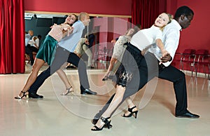 Adult couples dancing active dance together in modern studio