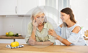 Adult daughter asks for forgiveness from elderly mother after quarrel in kitchen