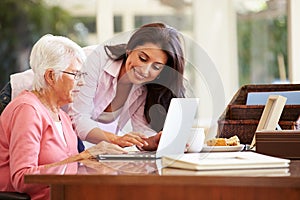 Adult Daughter Helping Mother With Laptop