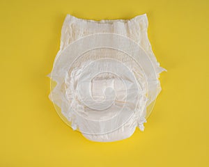 Adult diaper on a yellow background. Incontinence problems.