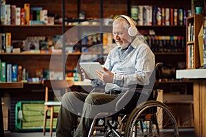 Adult disabled man in wheelchair listen to music