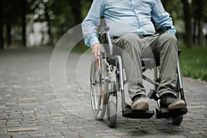 Adult disabled man in wheelchair resting in park