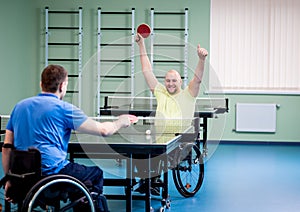 Adult disabled men in a wheelchair playing table tennis