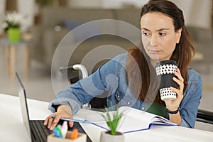 adult disabled woman drinking coffee while using laptop