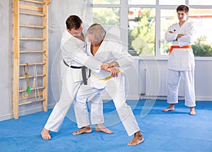 Adult and elderly men training judo fight