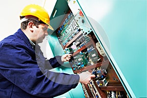 Adult electrician builder engineer worker testing electronics in switch board