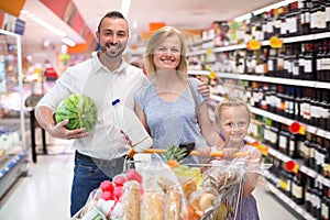 Adult family with kid shopping in hypermarket