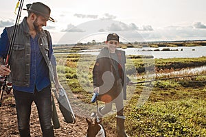 Adult father and teenager son going to fishing together.