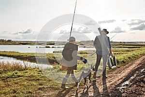 Adult father and teenager son going to fishing together.