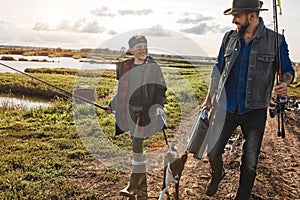 Adult father and teenager son going to fishing together.