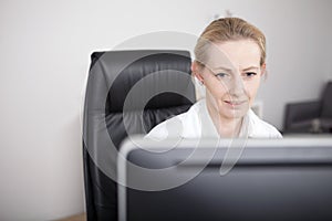 Adult Female Doctor Looking at her Computer Screen