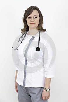 Adult female doctor with a stethoscope against a white wall