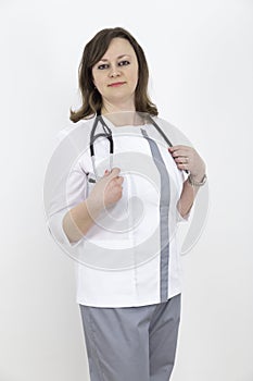 Adult female doctor with a stethoscope against a white wall. experienced doctor who inspires confidence. Woman hospital worker