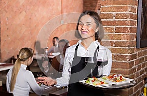 Adult female waiter showing country restaurant