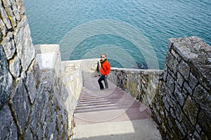 Adult female walks down on the Forty Steps on the Rhode Island Cliff Walk on a spring day