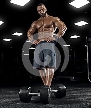 Adult guy bodybuilder posing in gym