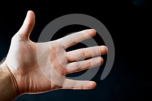 Adult hand with Raynaud`s Syndrome - Phenomenon. Close up hand with fingers on dark background with copy space