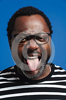 Adult happy african american man smiling and sticking out his tongue