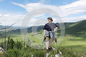 The adult happy woman standing on mountain top with sti