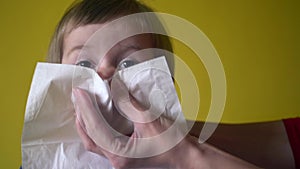 Adult helping little girl to blow nose, face closeup shot