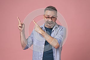 Adult hispanic man over isolated pink background smiling and looking at the camera pointing with two hands and fingers