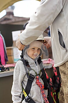 Adult instructor puts equipment on a 5-year-old boy for extreme sports