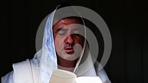 Adult Jewish man praying in the dark