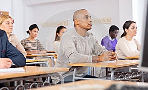 Adult latin american man listening to lecture in classroom