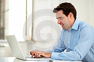 Adult latin enterpreneur using his laptop