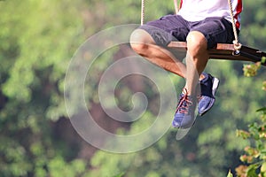 Adult legs sitting on swing  loneliness playing in the park