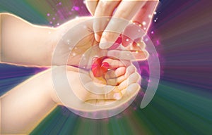 Adult and little child holding red hearts, and close up  on black background