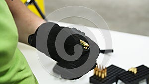 Adult loading an assault rifle at a shooting range.