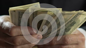 Adult mafia boss counting dollars, business person hands holding money, closeup