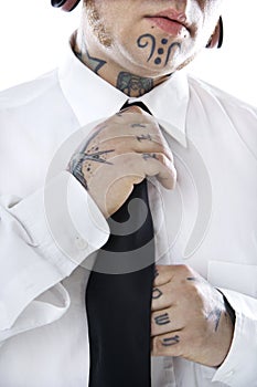 Adult male adjusting necktie.