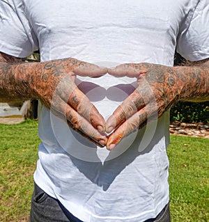 Adult Male With Dirty Tattooed Hands Making A Heart Gesture