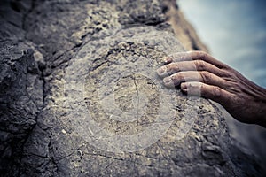 Adult male handholding on to a rock