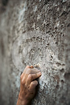 Adult male handholding on to a rock