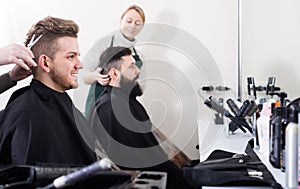 Adult male having their hair cut by hairdressers