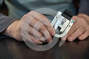 An adult male holding a top roller mount for a sliding closet system. Adjustable mounting plate for sliding doors. Furniture