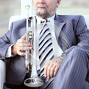 Adult male musician sitting in a chair