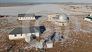 An adult male observatory worker stands on the observation deck of the observation dome and looks into the distance