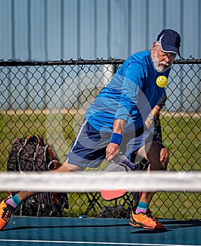 Adult male pickleball player with eyes on the ball