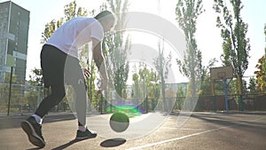 Adult male is playing basketball outdoor alone