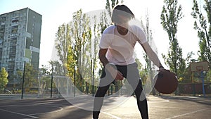 Adult male is playing basketball outdoor alone