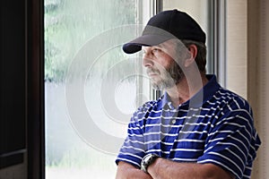 Adult Male Ponders Future Looking Out Rain Covered