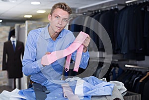 Adult male purchaser choosing tie