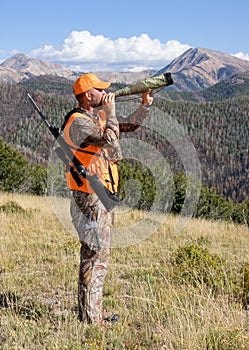 Elk hunter calling for elk in rugged mountains