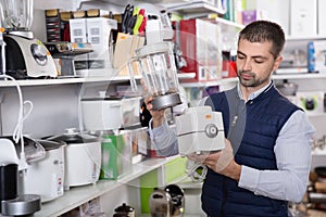 Adult male is standing with new blender for his home in the store