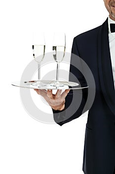 Adult male waiter serving two glass of champagne isolated