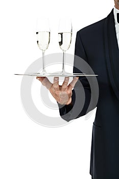 Adult male waiter serving two glass of champagne isolated